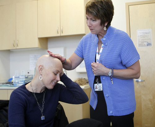 Al Hartmann  |  The Salt Lake Tribune
Julie Stillman, a patient navigator, right, rubs the bald head of breast cancer patient Cerise Nichol to see if her hair has started to grow in before fitting her with a new wig. Intermountain Medical Center, which is paving new ground in its team approach to cancer care. Cancer cuts across many departments, from surgery and oncology to genetics and radiology. Providers from each of these disciplines pow wow monthly to weigh the best course of treatment for complicated patients like Cerise. They also mine patient data to guide their decisions. And sometimes the data show the best test or procedure is the most expensive one, says an oncologist who published research that he says is proof of the need to leave health decisions in the hands of doctors instead of insurers.