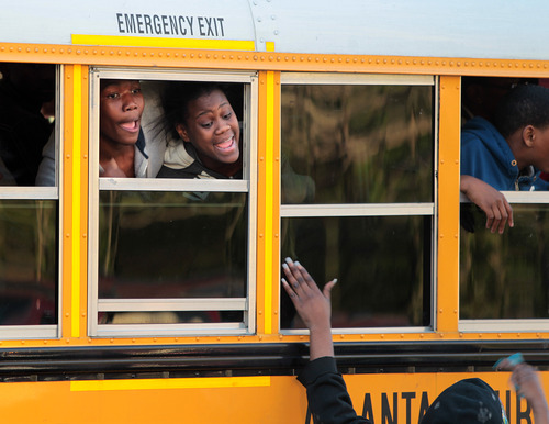 A student and parent react to seeing each other when buses arrive to unite parents and children at Emmanuel Baptist Church following a shooting at Price Middle school in Atlanta on Thursday, Jan. 31, 2013. A 14-year-old boy was wounded outside the school Thursday afternoon and a fellow student was in custody as a suspect, authorities said. No other students were hurt. (AP Photo/Atlanta Journal-Constitution, Curtis Compton)  MARIETTA DAILY OUT; GWINNETT DAILY POST OUT; LOCAL TV OUT; WXIA-TV OUT; WGCL-TV OUT