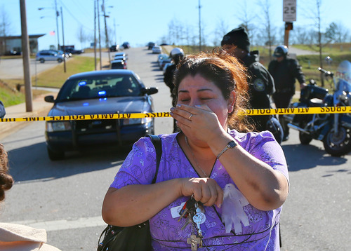 A distraught woman is turned back by police at the scene of a school shooting at Price Middle school in Atlanta on Thursday, Jan. 31, 2013. A 14-year-old boy was wounded outside the school Thursday afternoon and a fellow student was in custody as a suspect, authorities said. No other students were hurt. (AP Photo/Atlanta Journal-Constitution, Curtis Compton) MARIETTA DAILY OUT; GWINNETT DAILY POST OUT; LOCAL TV OUT; WXIA-TV OUT; WGCL-TV OUT