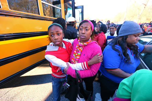 Mother and daughter embrace as Tiffany Myricle, 37, leads her daughter Xavia Denise Myricle away from her school bus when parents and children are reunited at Emmanuel Baptist Church after a shooting at an Price Middle school in Atlanta on Thursday, Jan. 31, 2013. A 14-year-old boy was wounded outside the school Thursday afternoon and a fellow student was in custody as a suspect, authorities said. No other students were hurt. (AP Photo/Atlanta Journal-Constitution, Curtis Compton)  MARIETTA DAILY OUT; GWINNETT DAILY POST OUT; LOCAL TV OUT; WXIA-TV OUT; WGCL-TV OUT