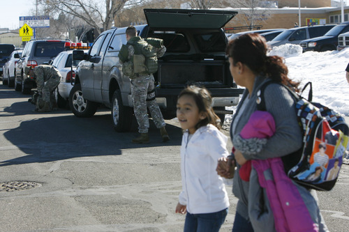 Francisco Kjolseth | The Salt Lake Tribune
A mother takes her daughter home from school as SWAT Team members from the Unified Police Department swarm a nearby Kearns residence where an armed man allegedly holed up with his wife and baby. The man was taken into custody after a three-hour standoff and no one was injured. The nearby Western Hills Elementary School was placed on lockdown during the incident.