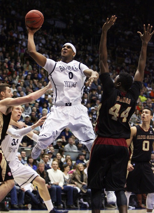 Kim Raff  |  The Salt Lake Tribune
(middle) Brigham Young Cougars forward Brandon Davies (0) shoots the ball as Santa Clara Broncos forward Yannick Atanga (44) defends during a game at the Marriott Center in Provo on February 2, 2013.  BYU went on to win 96-79.