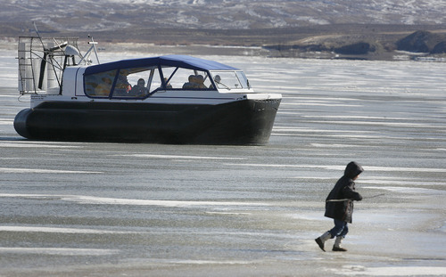 Scott Sommerdorf   |  The Salt Lake Tribune
A child walks on the ice on Flaming Gorge Reservoir as Daggett County's new hovercraft takes people for a ride on the ice. The Daggett County Sheriff's Office unveiled its new Amphibious Marine Hovercraft at Flaming Gorge Dam near Manila, Utah, Saturday, February 2, 2013.