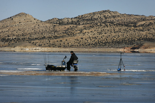 Scott Sommerdorf   |  The Salt Lake Tribune
Ice fisherman Clark Sabey sits on about 6 inches of ice as he fishes at Flaming Gorge Reservoir Saturday, February 2, 2013. The Daggett County Sheriff's Office unveiled its new Amphibious Marine Hovercraft at Flaming Gorge Dam near Manila, Utah, which could be used to rescue someone who has fallen through the ice.