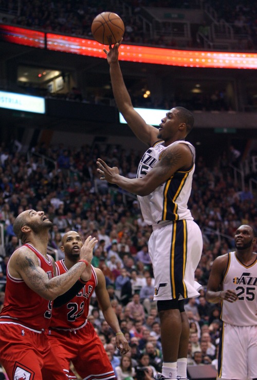 Kim Raff  |  The Salt Lake Tribune
Utah Jazz power forward Derrick Favors (15) shoots the ball over the head of (front left) Chicago Bulls power forward Carlos Boozer (5) and (back) Chicago Bulls power forward Taj Gibson (22) at EnergySolutions Arena in Salt Lake City on February 8, 2013. Jazz went on to lose the game 93-89.