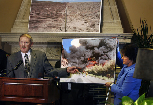 Scott Sommerdorf   |  The Salt Lake Tribune
Dick Buehler, director of the Utah Division of Forestry, Fire and State Lands, speaks as Sen. Margaret Dayton, R-Orem, holds up a photo of a fire during a news conference about wildfire bills SB120 and SB62 in the Senate Lounge, Thursday, February 7, 2013.