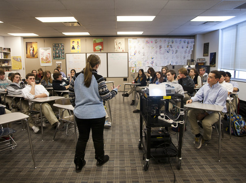 Nicole Veltri, theology teacher at Juan Diego Catholic High School, discusses Pope Benedict XVI's announcement to resign at the end of February with her class of juniors. (CAYCE CLIFFORD/Special to The Tribune)