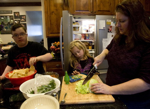 Kim Raff  |  The Salt Lake Tribune
Amy Simmons finishes up cooking dinner with two of her adopted kids Jack, left, and Celeste at their home in Kamas on January 24, 2013.  John and Amy Simmons have nine children with five adopted from Russia, including Celeste.