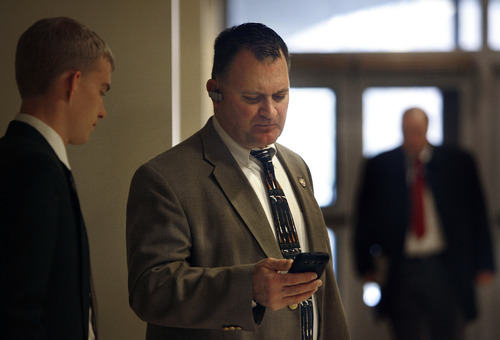 Scott Sommerdorf   |  The Salt Lake Tribune
Clark Aposhian, center, checks his phone messages while waiting for a meeting in the House building at the Utah State Capitol complex, Wednesday, February 6, 2013. Aposhian spends long days at the capitol every day during the legislative session advocating for gun rights.  At left is Rep. Curt Oda's intern, Nate Osborne.