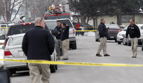 Al Hartmann  |  The Salt Lake Tribune
Unified Police officers investigate a triple homicide at 8286 S. 450 West (Adams Street) in Midvale on Tuesday, Feb, 12.   Up to 80 officers were involved in a manhunt for a male suspect.