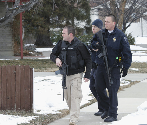 Al Hartmann  |  The Salt Lake Tribune
Unified Police officers investigate a triple homicide at 8286 S. 450 West (Adams Street) in Midvale on Tuesday, Feb, 12. Up to 80 officers were involved in a manhunt for a male suspect.