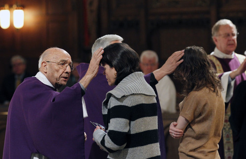 Al Hartmann  |  The Salt Lake Tribune
Deacon Silvio Mayo, left, makes the sign of the cross in ash on the foreheads of Catholic faithful at the Cathedral of the Madeleine  on Wednesday, Feb. 13 as part of Ash Wednesday observance.