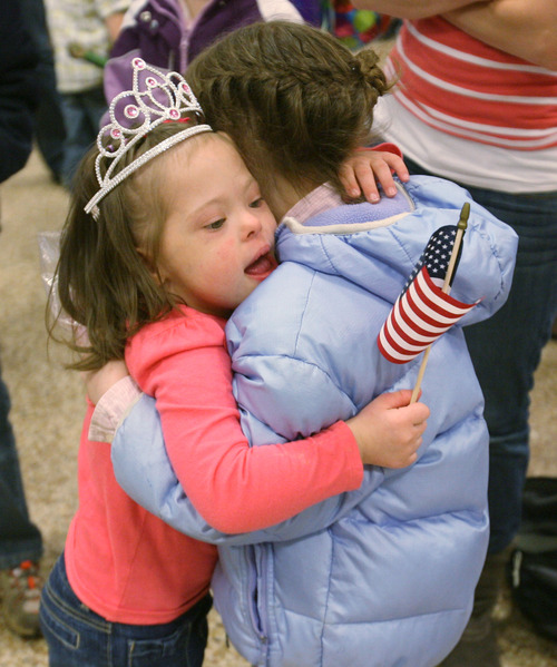 Steve Griffin | The Salt Lake Tribune
Jaymi Bonner, center, gets a big hug from her new cousin, Jackie Rasmussen, at the main terminal at the Salt Lake City International Airport in Salt Lake City, Utah Thursday, February 14, 2013. Jaymi and her mother, Jeana Bonner, arrived home today after weeks spent in Russia trying to finalize the adoption of 5-year-old Jaymi, who has Down syndrome. The Russian government in January approved a ban on adoptions by U.S. citizens, but agreed to let adoptions that were already basically completed to proceed. This was one of about 50 adoptions allowed to move forward.