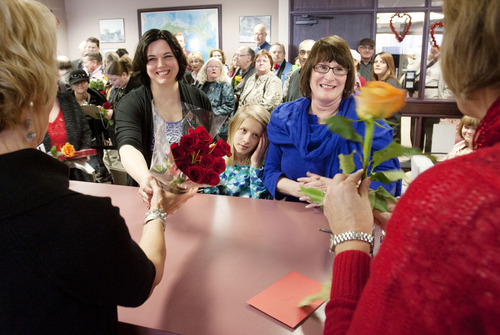 Steve Griffin  |  The Salt Lake Tribune
Michelle Hasting, left, her wife,  Jamila Tharp, right, and their daughter Abigail Hasting-Tharp hand roses to Dahnell Burton-Lee and Darylne McPheeters, who work in the Marriage and Passport department for Salt Lake County, as they apply for a marriage license during the "Standing on the Side of Love" marriage equality rally at the Salt Lake County Government Center on Thursday. Several same-sex couples attended the rally and applied for marriage licenses. They were politely informed of Utah state statute prohibiting marriage between persons of the same sex.