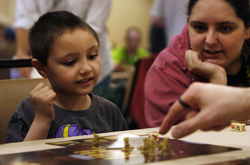 Scott Sommerdorf   |  The Salt Lake Tribune
Donaven Archibald, 5, left, watches with his mother Meghan Bomberg as they play a game of "Mice and Mystics" at SaltCON 2013, a board game convention at Sheraton Salt Lake City Hotel, Saturday, Feb. 15, 2013. The Ion Award Game Design Competition, for both unpublished and newly published designers, gives contestants a chance to show off their work to industry experts at SaltCON.