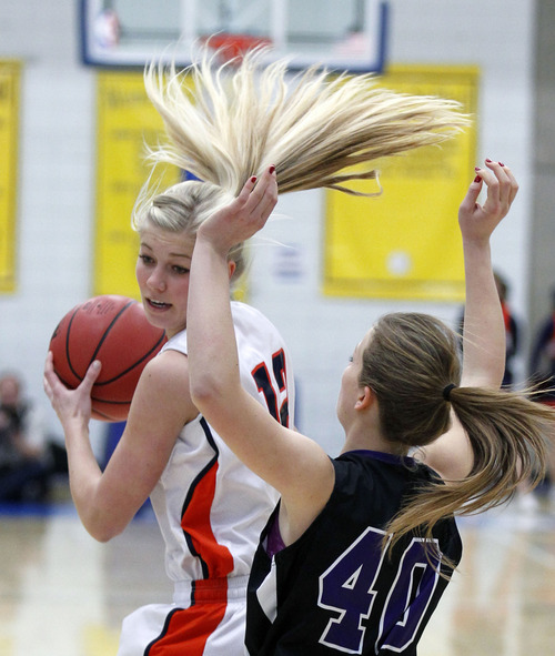 Al Hartmann  |  The Salt Lake Tribune
Brighton High School's Mccall Christensen's hair flies as she runs into the  defense of Riverton High School's Whitney Saunders at the 5A girls' playoff game at Salt Lake Community College Monday February 18.