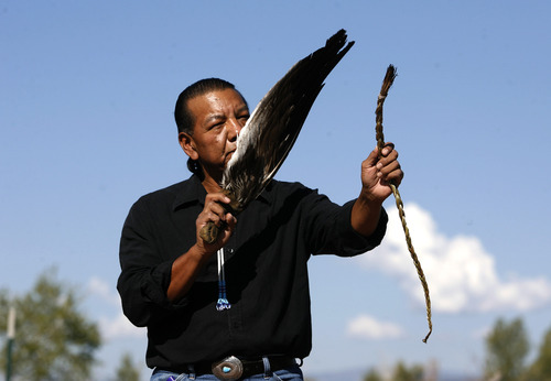 Rick Egan | The Salt Lake Tribune

Larry Cesspooch holds an eagle feather and a strand of sweet grass as he says  a prayer at the the dedication of a historical marker in 2009.  Cesspooch, a Ute, educates about what the symbols represent to Native Americans.