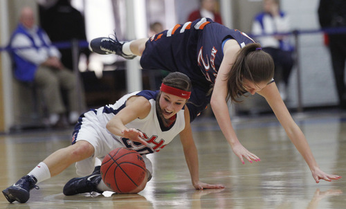 Al Hartmann  |  The Salt Lake Tribune
Springville School's Savannah Park keeps control of the ball as she gets forced down as Mtn. Crest High School's Kiera Knight goes over her back during a Girl's 4A play off game at Salt Lake Community College Tuesday, February 19.