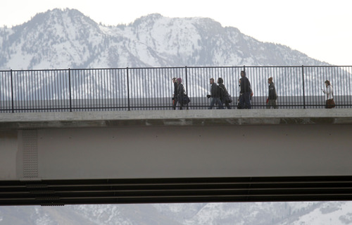 Al Hartmann  |  The Salt Lake Tribune
TRAX passengers walk north along 300 West to the next station near 5300 as UTA crews clear SUV that was hit in an accident near 5900 South 300 West Tuesday February 19.