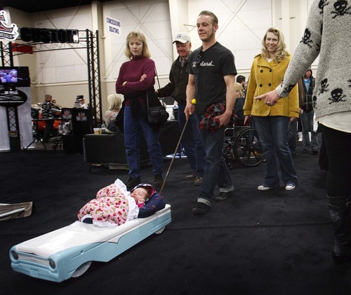 Leah Hogsten  |  The Salt Lake Tribune
Steve and Cheyanne Ward got lots of comments on their 8-week-old daughter Ruby's custom Ford pedal car stroller at the show. Over 300 custom cars, classics, hot rods, trucks, motorcycles and race cars are on display at The 39th Annual Parts Plus Autorama at the South Towne Expo Center, February 23, 2013. The show ends Sunday, February 24, 2013