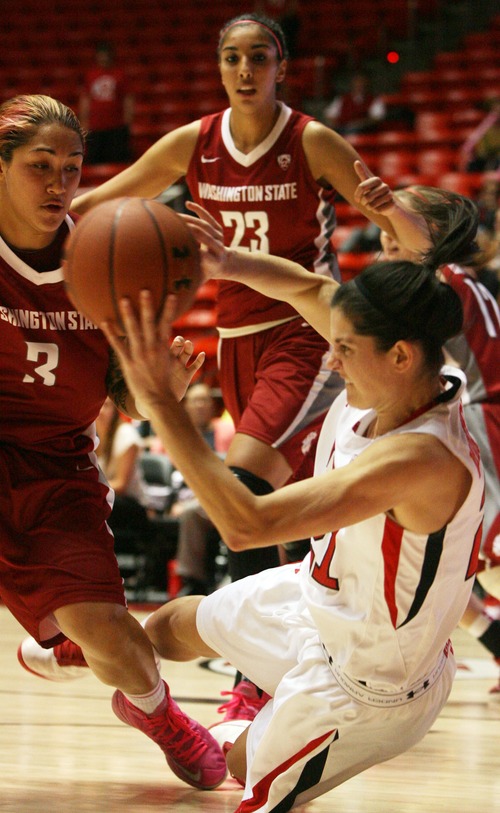 Kim Raff  |  The Salt Lake Tribune
University of Utah player (right) Chelsea Bridgewater passes the ball past Washington State player (left) Lia Galdeira as she falls to the court during a game at the Huntsman Center in Salt Lake City on February 24, 2013. Utah went on to win 59-47.