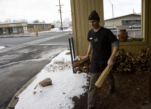 Kim Raff  |  The Salt Lake Tribune
Loren MacLaren stocks the bbq smoker with wood outside of Sugarhouse BBQ Company in Salt Lake City on Friday February 22, 2013. Sugarhouse BBQ Company is moving to 2100 S. 900 East. Owners say the Trolley project will cut down on their parking so they will be forced to move from their current location at 2207 S. 700 East.