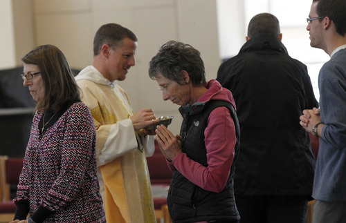 Al Hartmann  |  The Salt Lake Tribune
Father Carl Schlichte of St. Catherine of Siena Catholic Newman Center at the University of Utah serves communion during a Mass on Thursday marking the retirement of Pope Benedict XVI.