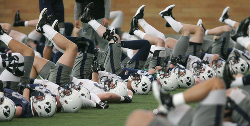 Steve Griffin | The Salt Lake Tribune

The BYU football team warms up during spring practice at the indoor practice facility at BYU in Provo, Utah Monday March 4, 2013.