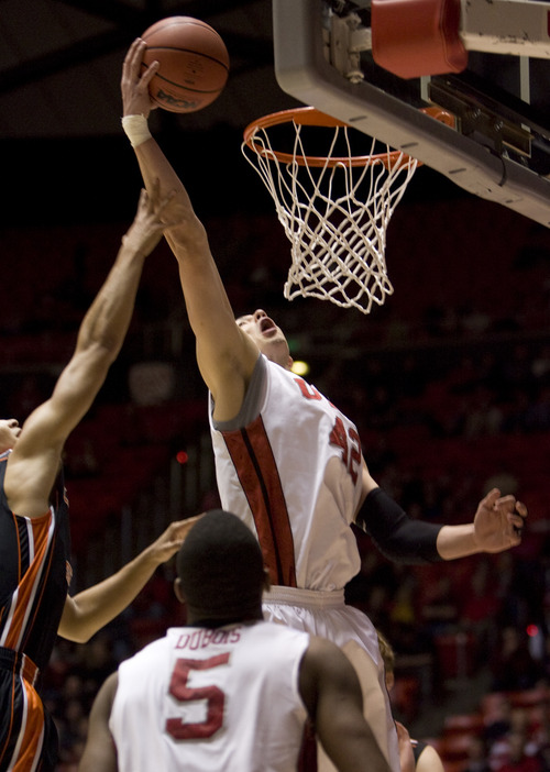 Kim Raff  |  The Salt Lake Tribune
Utah Utes center Jason Washburn (42) scores two on a rebound as (left) Oregon State Beavers guard Challe Barton (4) defends during a game at the Huntsman Center in Salt Lake City on March 7, 2013. Utah went on to win 72-61.
