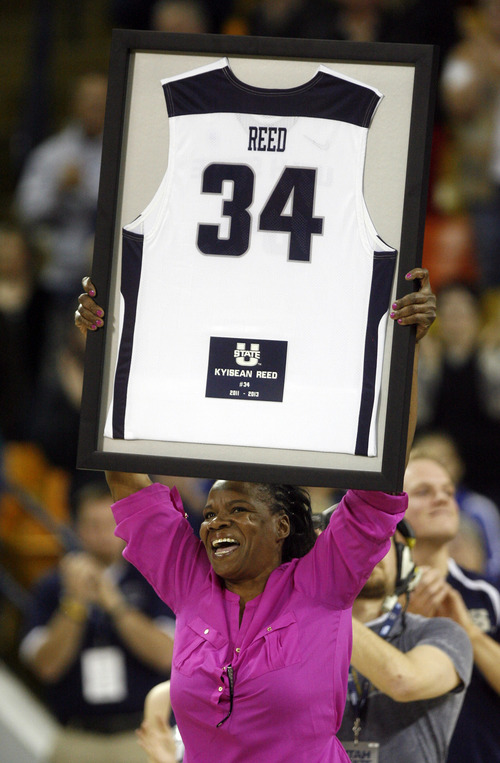 Rick Egan  | The Salt Lake Tribune 

Angela Reed holds her son's Jersey while the crowd cheers in the pre-game ceremony recognizing Kyisean Reed as an out-going senior, before the Aggies faced the University of Texas at San Antonio Roadrunners, in Logan, Saturday, March 9, 2013.