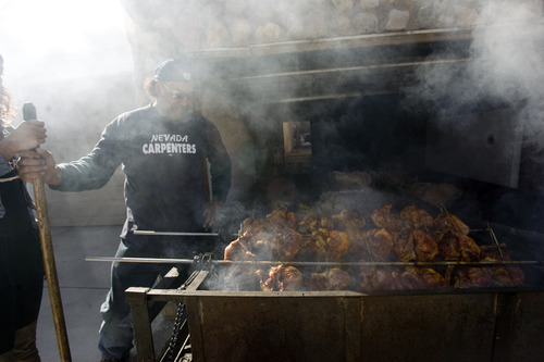 Kim Raff  |  The Salt Lake Tribune
In the warm afternoon sun (left) Sione Tauteoli roasts 26 chicken quarters in his driveway over his handmade spit in Salt Lake City on March 9, 2013.