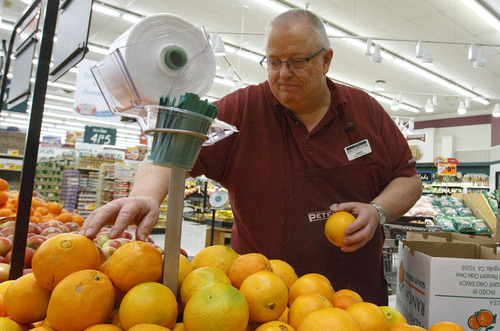 Leah Hogsten  |  The Salt Lake Tribune
Produce manager Dennis Eyre restocks oranges at Peterson's grocery Saturday, March 9, 2013. In early summer, the Peterson family will move its long-time business across the street, to 1784 W. 12600 South, to a larger space in a Fresh Market store, which will close.