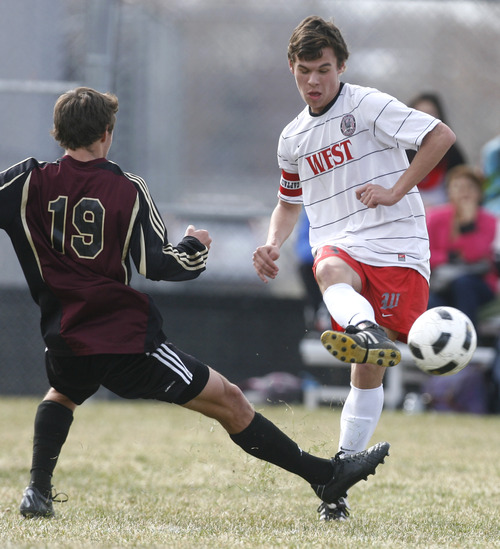 Rick Egan  | The Salt Lake Tribune 

Alex Cody (23) West High,  kicks the ball, as Ryan Morrin (19) defends, in prep soccer action Lone Peak vs. West, at West High, Monday, March 11, 2013.