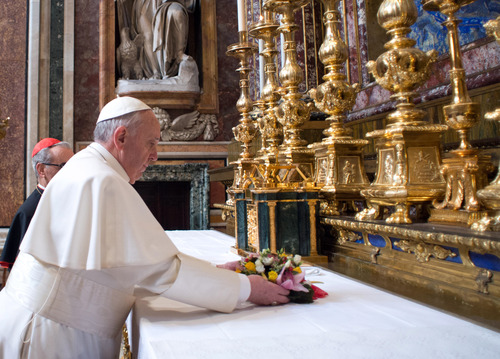 In this photo provided by the Vatican newspaper L'Osservatore Romano, Pope Francis puts flowers on the altar inside St. Mary Major Basilica, in Rome, Thursday, March 14, 2014. Pope Francis opened his first morning as pontiff by praying Thursday at Rome's main basilica dedicated to the Virgin Mary, a day after cardinals elected him the first pope from the Americas in a bid to revive a Catholic Church in crisis and give it a preacher with a humble touch. (AP Photo/L'Osservatore Romano, ho)