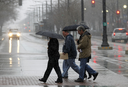 Al Hartmann  |  The Salt Lake Tribune
People walk across Main Street in Salt Lake City Friday morning March 22 bundled up for winter weather during a Spring snowstorm.