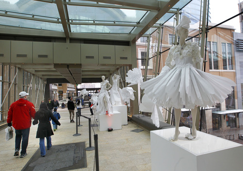 Al Hartmann  |  The Salt Lake Tribune
Shoppers pass by elaborate dresses and flowers made of white paper in City Creek Center's sky bridge Friday March 22nd.    City Creek Center is celebrating its one-year anniversary today and Saturday with sales, promotions and live music.