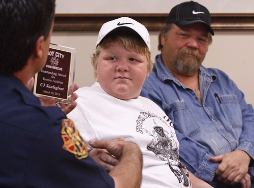 Leah Hogsten  |  The Salt Lake Tribune
Twelve-year-old C.J. Saulsgiver of Roy performed CPR on his mother to save her life on his birthday. C.J.'s father, Doc, watches as C.J. is presented with an award for his heroic actions from Roy Fire Department Chief Jason Poulsen Friday at McKay-Dee Hospital. C.J. learned the skill only months ago through a foster care safety training course.
