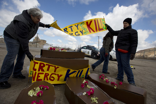 Lennie Mahler  |  The Salt Lake Tribune
Carma Logie and Denise Davis set up a display of coffins and signs protesting oil extraction from tar sands in front of the Chevron oil refinery north of downtown Salt Lake City. Members of Utah Tar Sands Resistance and other groups voiced concerns about damage to the environment, wildlife, and public health. Saturday, March 23, 2013.