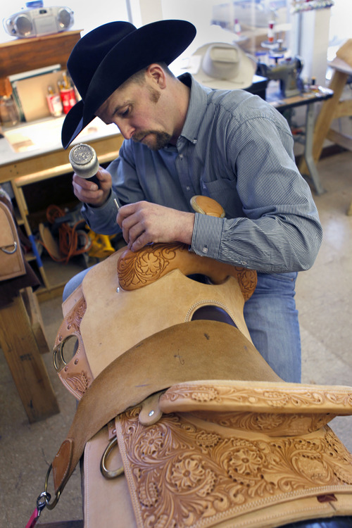 Al Hartmann  |  The Salt Lake Tribune
Matt Warner, head of design, stamps a floral pattern into the leather on the swell of a custom-made saddle at Burns Saddlery shop in Salina.