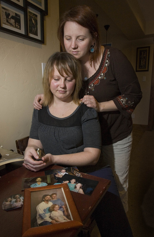 Paul Fraughton  |   Salt Lake Tribune
Ahren Exeter, front,  and her sister Erica Castledine look at  family photos of their father who died several years ago waiting for a liver donor. Ahren holds a small urn holding  some of her father's ashes
 Monday, March 18, 2013