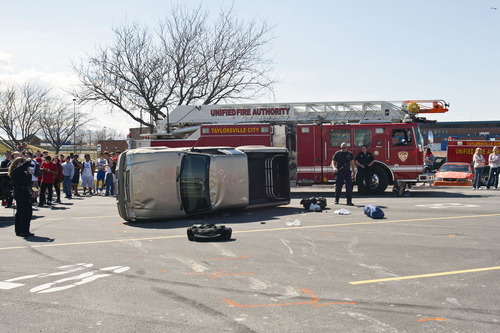 Chris Detrick  |  The Salt Lake Tribune
Students look at the scene of a tuck rollover at Taylorsville High School Wednesday March 27, 2013. Two students, including the driver, were injured when the truck rolled over. There were five total people in the truck, three in the bed and two in the cab, at the time of the accident.