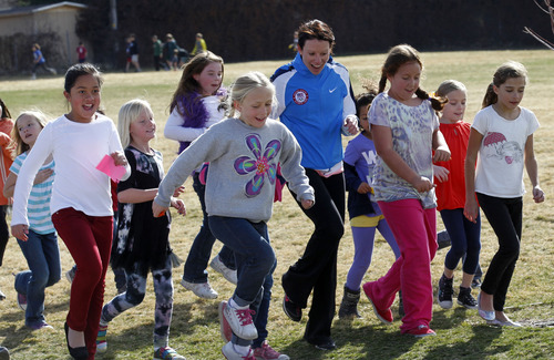 Al Hartmann  |  The Salt Lake Tribune
Crestview Elementary School students do some fancy footwork while running 1 mile around the school field with two-time olympian and five time national aerial freestyle skier Emily Cook, center,  Tuesday March 19 as part of  the Jolly Jogger Program, which is aimed at getting consistent physical education in all schools because of its benefits for brain activity.  Local Athletes for Hope joined them in the assembly and run.