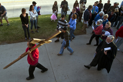 Chris Detrick  |  The Salt Lake Tribune
Alex Bury, of Sunset, carries a wooden cross from the Cathedral of the Madeleine to First Presbyterian Church during the Good Friday Procession of the Cross Friday March 29, 2013. Since 1983, the Salt Lake Council of Churches has sponsored this annual procession, which is similar to the tradition of the "Via Dolorosa" (Way of Suffering), where pilgrims to Jerusalem follow the path Jesus took to the cross.
