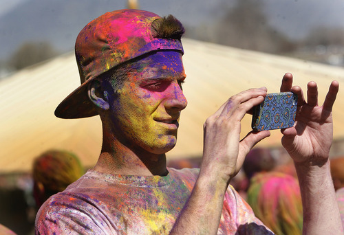 Scott Sommerdorf   |  The Salt Lake Tribune
A celebrant full of colors makes a photo of friends at the 2013 Festival of Colors - Holi Celebration - takes place at the Krishna Temple in Spanish Fork, Saturday, March 30, 2013. The festival celebrates Holi, the announcement of the arrival of spring.
