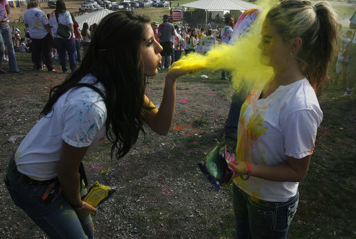 Scott Sommerdorf   |  The Salt Lake Tribune
Aubrie Lamph blows yellow color onto her friend Ashlyn Zentner at the 2013 Festival of Colors - Holi Celebration - The Krishna Temple in Spanish Fork will celebrate Holi, the announcement of the arrival of spring, Saturday, March 30, 2013.
