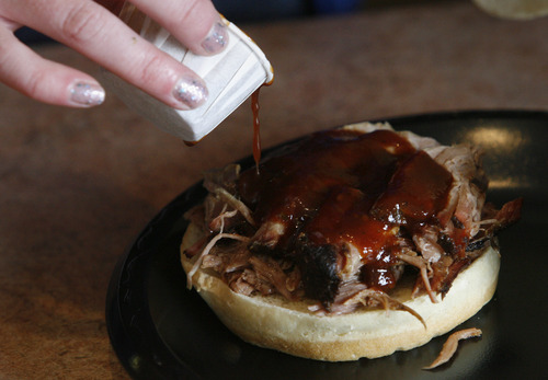 Rick Egan  | The Salt Lake Tribune 

Sweet and Sassy Sauce is poured on a pork sandwich, at Richard's Round Up Barbecue on Main Street in Grantsville, Thursday, February 28, 2013.