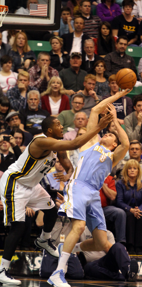 Rick Egan  | The Salt Lake Tribune 

Utah Jazz power forward Derrick Favors (15) defends, as Denver Nuggets small forward Danilo Gallinari (8) gets off a shot for 2 points, in NBA action at the EnergySolutions Arena, Wednesday, April 3, 2013.