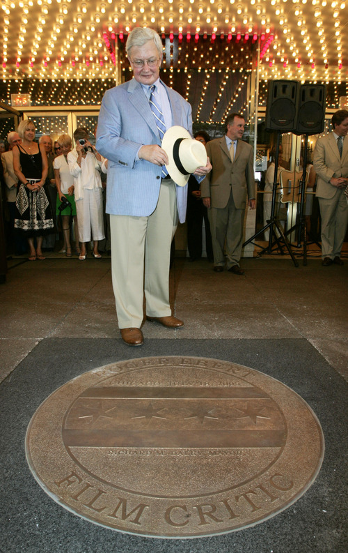 FILE - This July 18, 2005 file photo shows film critic Roger Ebert next to a sidewalk medallion bearing his name that was unveiled under the marquee of the historic Chicago Theatre. The Chicago Sun-Times is reporting that its film critic Roger Ebert died on Thursday, April 4, 2013. He was 70.  (AP Photo/Charles Rex Arbogast, file)
