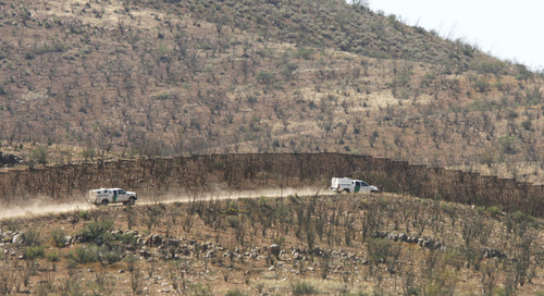 U.S. Border Patrol vehicles parallel the U.S.-Mexico border fence in the area where a Border Patrol agent was shot and killed on Tuesday October 2, 2012 west of Douglas, Arizona.  One agent was killed and another wounded in the incident.    (AP Photo/Arizona Daily Star, Benjie Sanders)  ALL LOCAL TV OUT; PAC-12 OUT; MANDATORY CREDIT