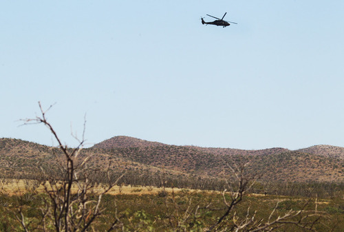 A U.S. Customs and Border Protection helicopter flies overhead near the scene where a Border Patrol agent was killed early Tuesday, Oct. 2, 2012, near Naco, Ariz. The shooting occurred after an alarm was triggered on one of the thousands of sensors placed by the U.S. government along the border, and the agents went to investigate, said Cochise County Sheriff's spokeswoman Carol Capas. (AP Photo/Arizona Daily Star, Mike Christy)